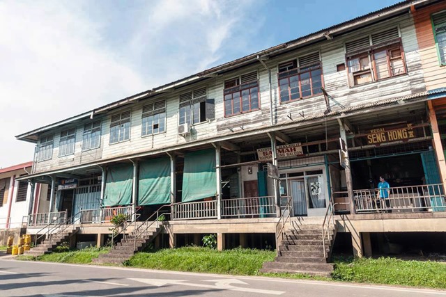 The remaining row of elevated wooden shophouses.